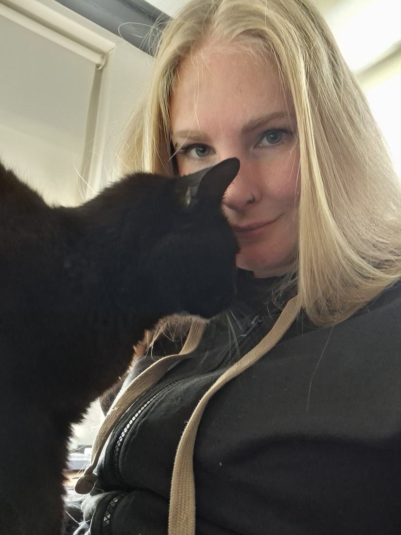 Anouk met een zwarte kat vlak bij haar gezicht
